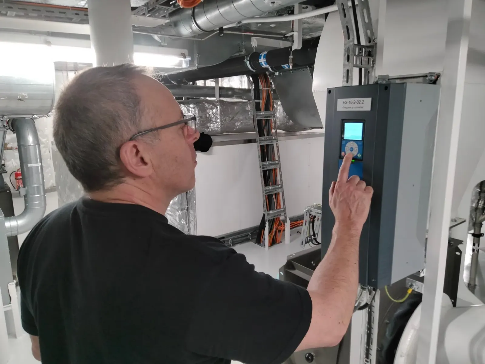 Technician inspecting a frequency converter on a ship
