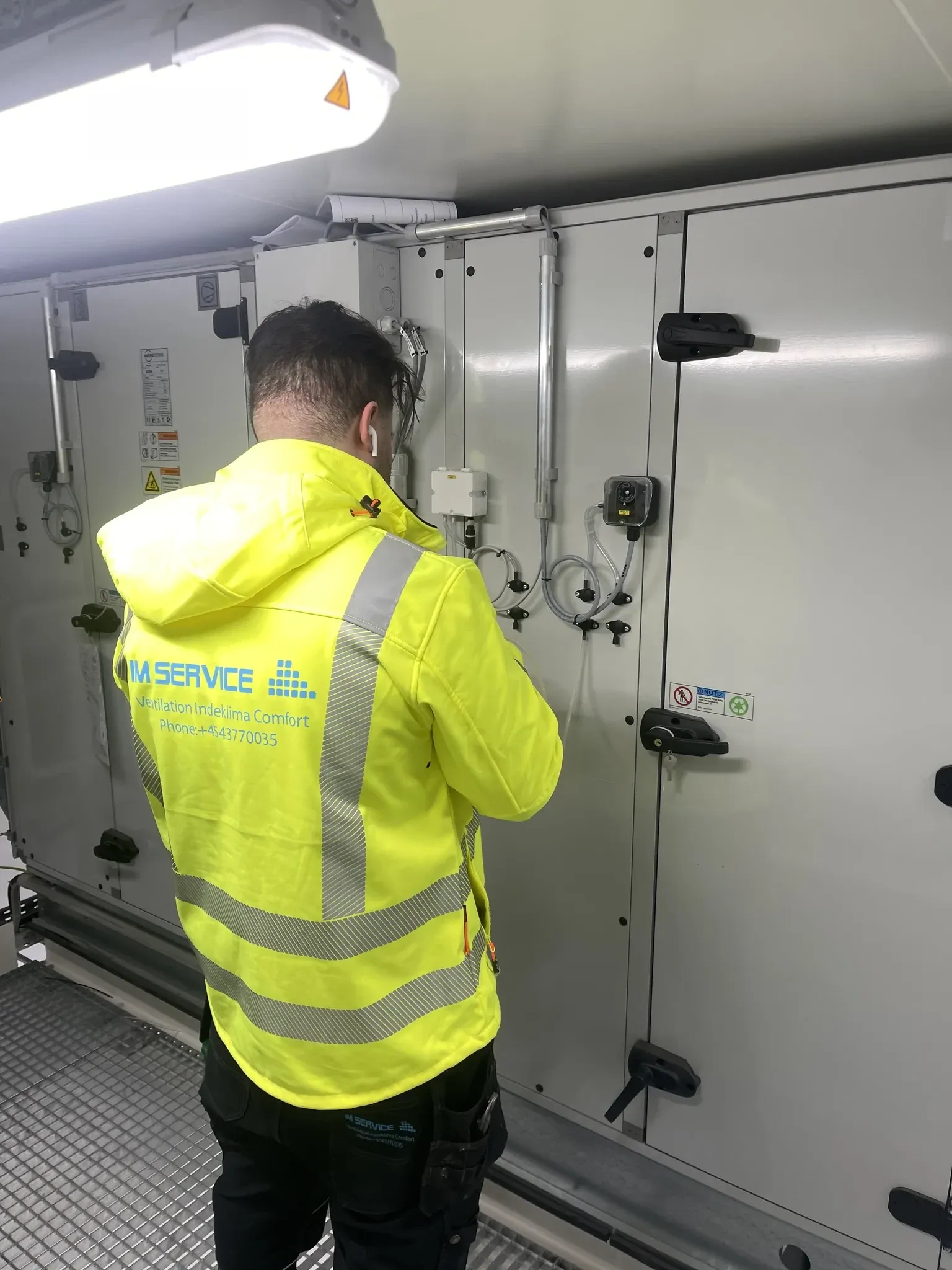 Tekniker i sikkerhedsvest inspicerer HVAC-anlæg